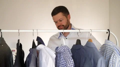 Man chooses clothes in wardrobe Stock Footage 157228051
