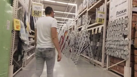 A man chooses a construction ladder in the store Stock Footage 78700168