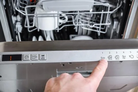 Man chooses an eco program on the control panel of the dishwasher. Foto stock