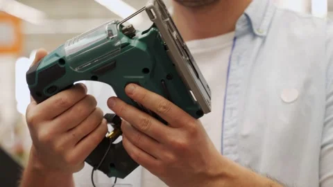 Man chooses an electric jigsaw in a hardware store Stock Footage 155299161
