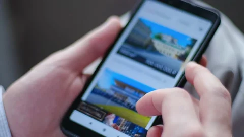 Man chooses housing using a smartphone in an online real estate agency Stock Footage 146333707