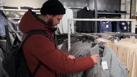 Man chooses jacket in a clothing store Stock Footage 264164676