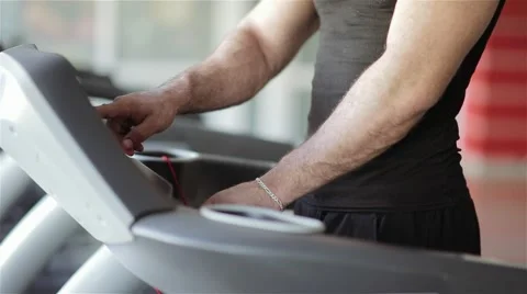 Man chooses a program on a treadmill in the gym Stock Footage 56635923