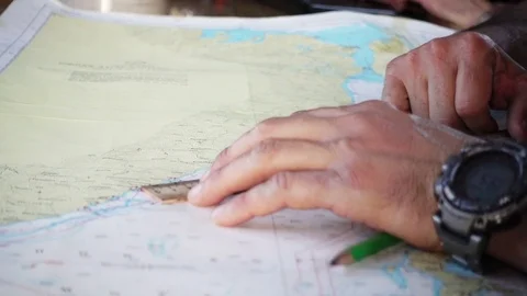 A man chooses a route on the sea map Stock Footage 80460417