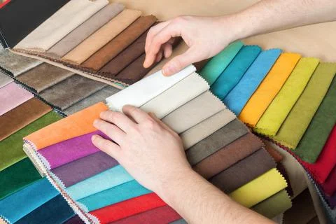 Man chooses samples of colored tissue Stock Photos