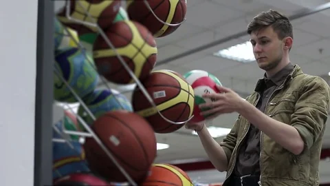 Man chooses sporting goods in the store Stock Footage 74806116