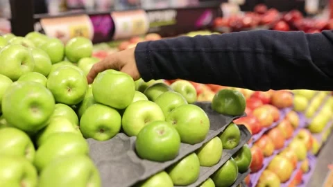 Man choosing apples in a grocery store. Close up of a mans hand with apples Stock Footage 235148068