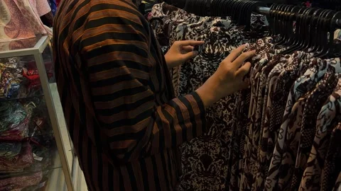 A man is choosing batik at a local batik shop Stock Footage 263603540