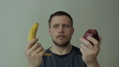Man choosing between apple and banana. Video stock 77324996