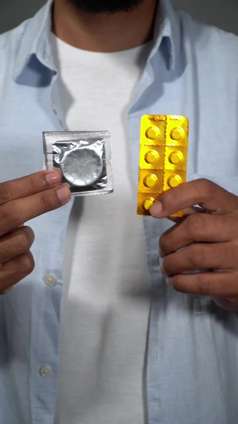 Man choosing between condom and emergency contraceptive pills Stock Footage 314384527
