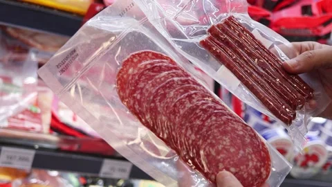 Man choosing between different packages of sausages at a grocery store Stock Footage 324874131
