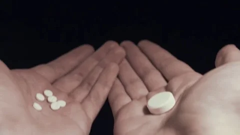 Man choosing between few small pills and one big pill on his hands take them all Stock Footage 69212384