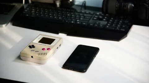 Man choosing between Nintendo Game Boy and smartphone. Stock Footage 118768299