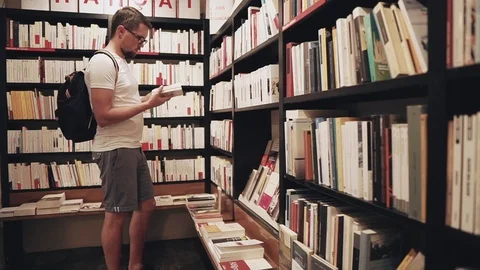 Man choosing a book in a store. Stock Footage 99598138