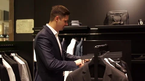 Man choosing business jacket from the raw in the shop Stock Footage 65554407