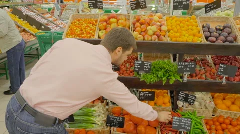 Man choosing a chilli peppers at supermarket Stock Footage 63371707