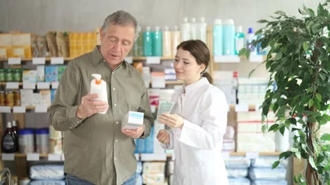 Man choosing cream with help from pharmacist Stock Footage 343708737