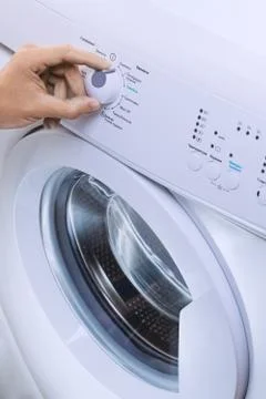 Man Choosing Cycle Program On Washing Machine Foto stock