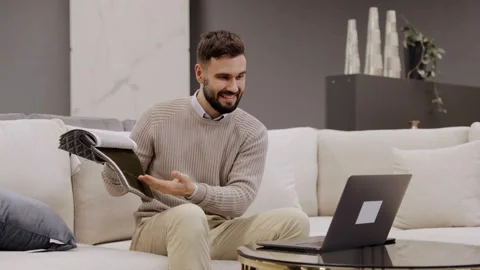 Man choosing fabric samples for home interior design sitting on sofa with laptop Stock Footage 334654226