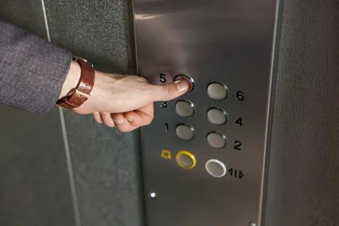 Man choosing floor in elevator, closeup view Stock Photos