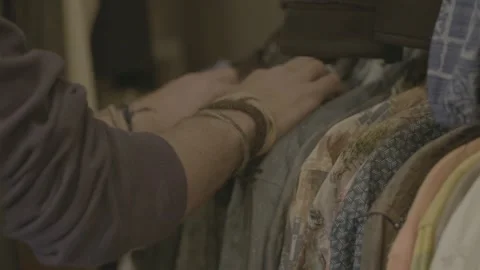 Man Choosing New Clothes in Store in Slow Motion Stock Footage 131357015
