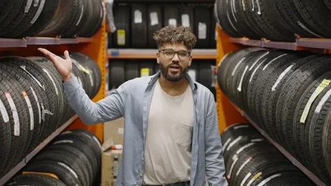 Man choosing new tires for his car in a shop Stock Footage 336965543