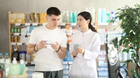 Man choosing ointment with help from pharmacist Stock Footage 342131609