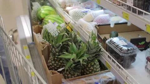 Man choosing pineapple at the supermarket Stock-Footage 72728433