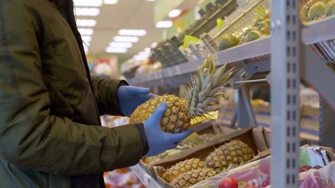 A man choosing pineapple in the supermarket Stock Footage 126834758