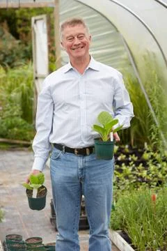 Man Choosing Plants At Garden Centre Stock Photos