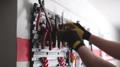 Man Choosing Pliers On A Mechanic's Tool Shelf Stock Footage 341574350