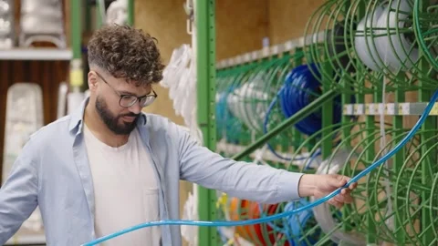Man choosing plumbing pipe in hardware store Video stock 336965736