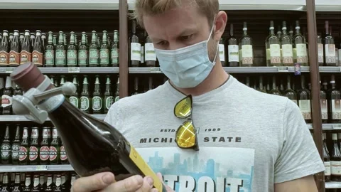 Man Choosing Red Wine at Store While Wearing a Mask During Covid-19 Pandemic Stock Footage 140926975