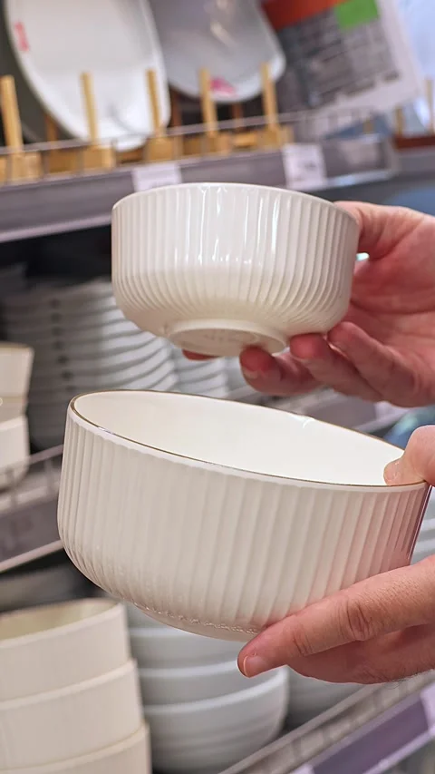 Man choosing white ceramic bowls in supermarket kitchenware department Stock Footage 337736165