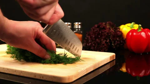 Man chopping dill on a cutting board on the kitchen table Stock Footage 39948522