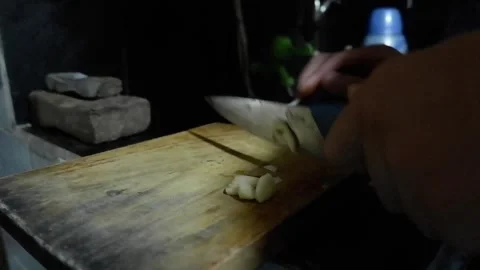Man chopping off garlics with left hand on wood cutting board Stock Footage 278398752