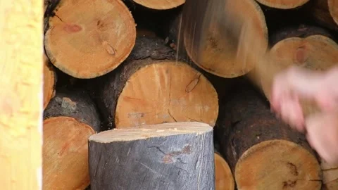 A man is chopping logs with an axe on chopping block. Harvesting of firewood Stock Footage 218259794