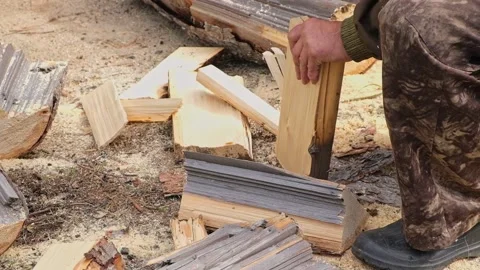 A man is chopping logs with an axe on chopping block. Harvesting of firewood Stock Footage 218259817