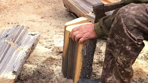 A man is chopping logs with an axe on chopping block. Harvesting of firewood Stock Footage 218614870