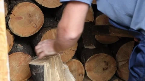 A man is chopping logs with an axe on chopping block. Harvesting of firewood Stock Footage 219751597