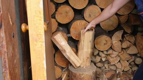 A man is chopping logs with an axe on chopping block. Harvesting of firewood Stock Footage 220099906