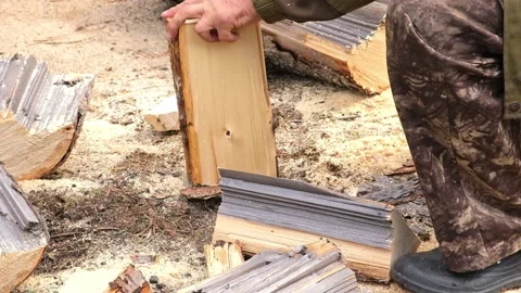 A man is chopping logs with an axe on chopping block. Harvesting of firewood Stock Footage 220099925