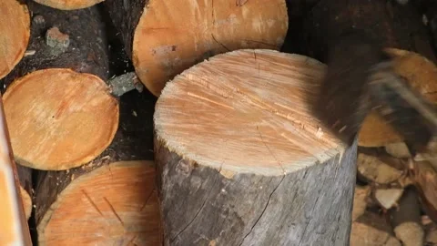 A man is chopping logs with an axe on chopping block. Harvesting of firewood Stock Footage 220523113