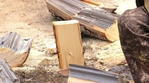 A man is chopping logs with an axe on chopping block. Harvesting of firewood Stock Footage 220523125
