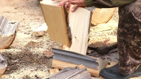 A man is chopping logs with an axe on chopping block. Harvesting of firewood Stock Footage 220886083