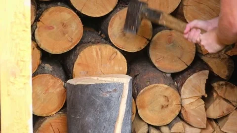 A man is chopping logs with an axe on chopping block. Harvesting of firewood Stock Footage 221583180