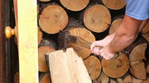 A man is chopping logs with an axe on chopping block. Harvesting of firewood Stock Footage 222016498