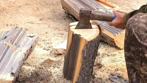 A man is chopping logs with an axe on chopping block. Harvesting of firewood Stock Footage 222016509