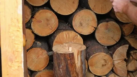 A man is chopping logs with an axe on chopping block. Harvesting of firewood Stock Footage 223229111