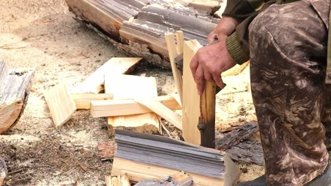 A man is chopping logs with an axe on chopping block. Harvesting of firewood Stock Footage 223229392